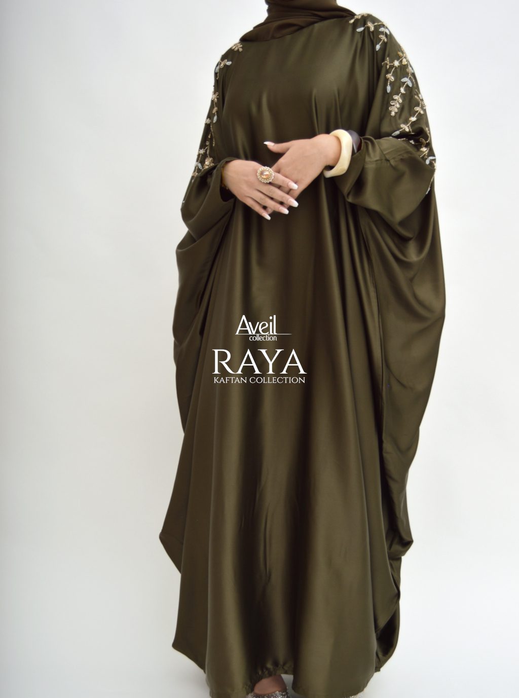 Model wearing Raya Luxury Closed Kaftan Abaya in satin with batwing silhouette and gold pearl embroidery